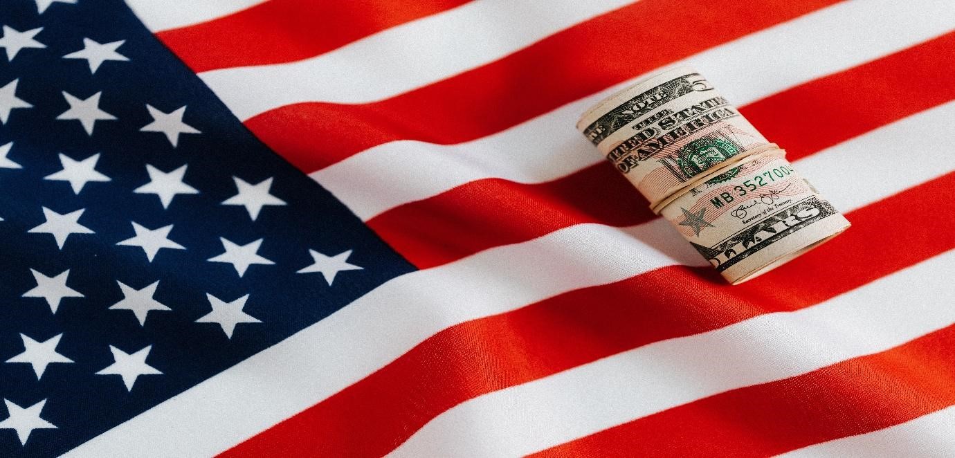 ps://www.pexels.com/photo/american-flag-with-rolled-dollar-bills-4386346/